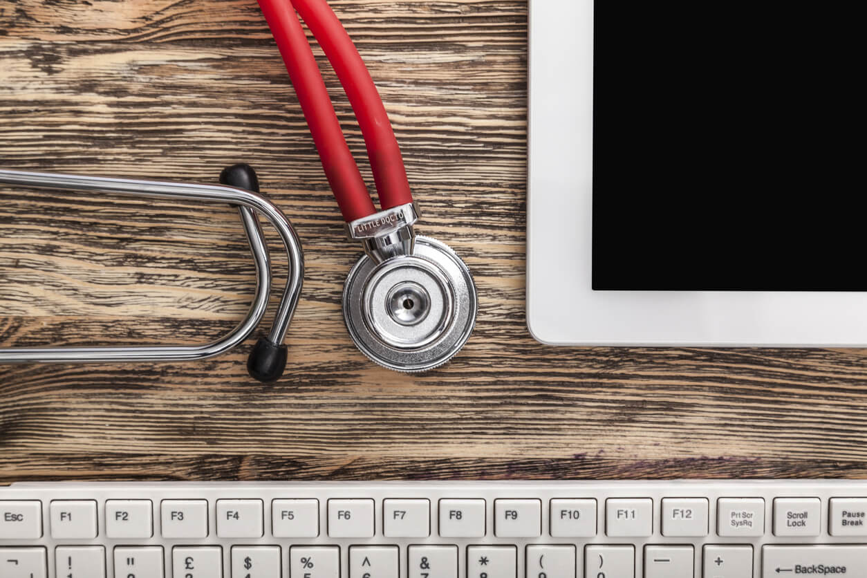 Medical stethoscope and computer on table background