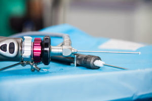 An arthroscope is prepared for use in the surgery room before post-arthroscopy care for a rotator cuff tear.