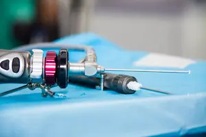 An arthroscope is prepared for use in the surgery room before post-arthroscopy care for a rotator cuff tear.