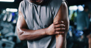 man in gym is experiencing bicep tendinopathy.